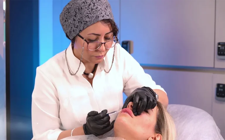 Dr. Mozhdeh Rezvani injecting filler to female patient's upper lip